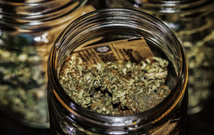 a glass jar filled with dense, trichome-rich cannabis buds.