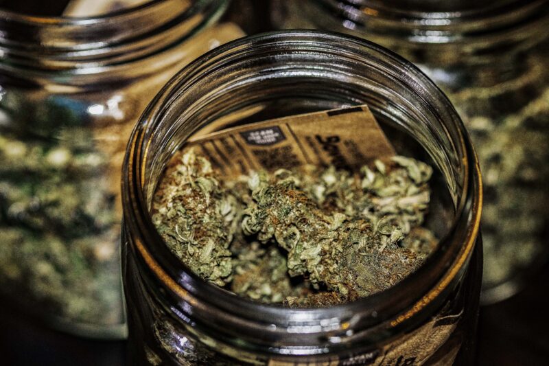 a glass jar filled with dense, trichome-rich cannabis buds.