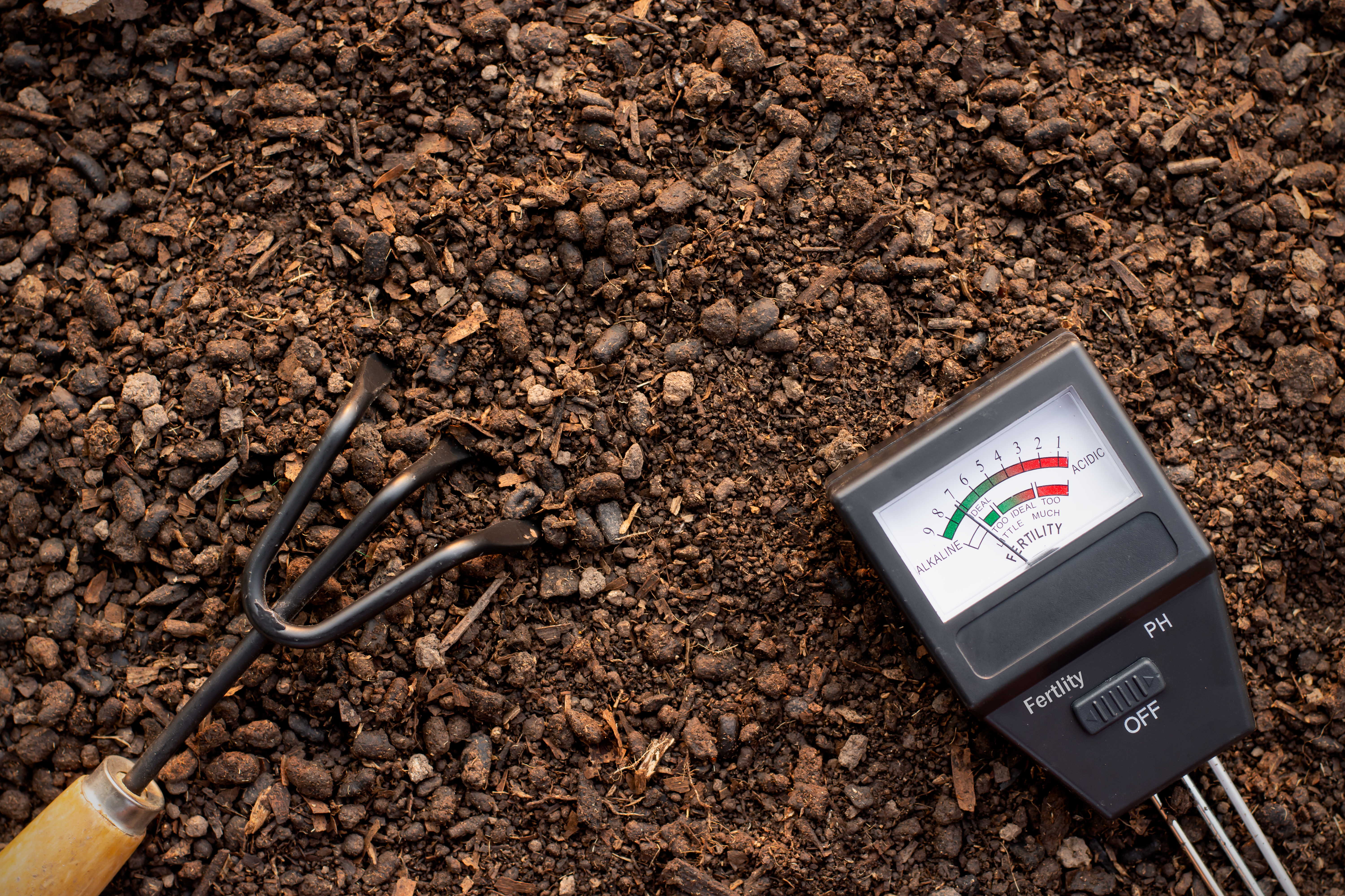 Soil meter and garden equipment on loam